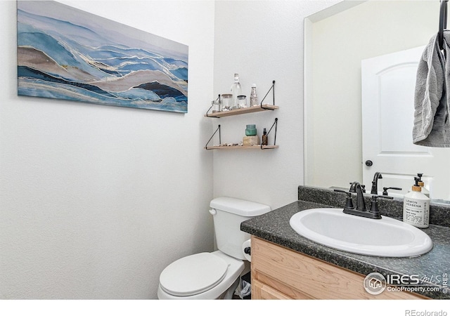 half bathroom featuring toilet and vanity