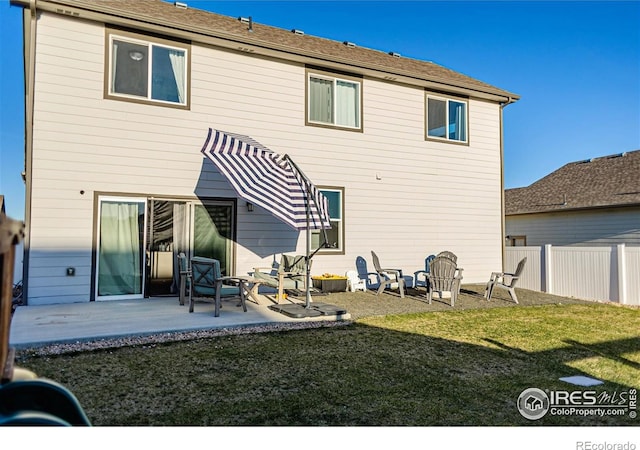 back of property featuring a yard, fence, and a patio area