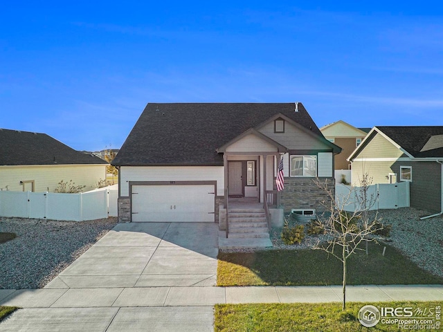 view of front of property featuring a garage, fence, driveway, and stone siding