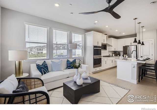 living room featuring ceiling fan and recessed lighting