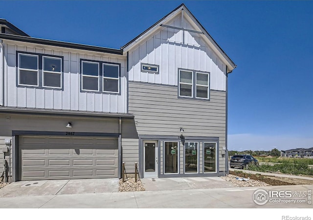 view of front of house featuring board and batten siding, concrete driveway, and a garage