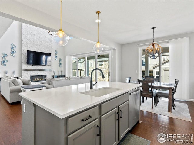 kitchen featuring a sink, dishwasher, a chandelier, plenty of natural light, and gray cabinetry