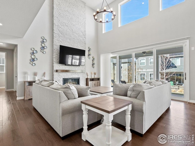 living area with a high ceiling, plenty of natural light, and baseboards