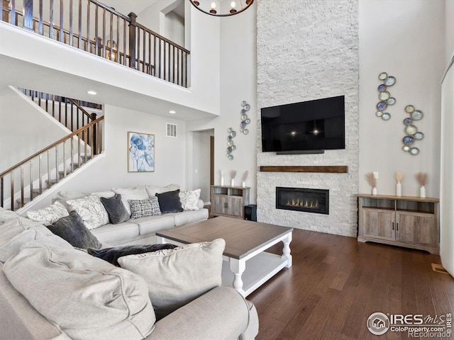 living room featuring visible vents, a towering ceiling, and a fireplace