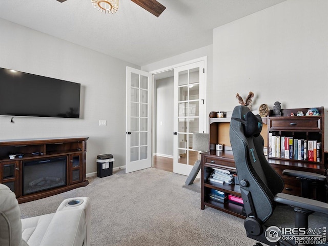 office with french doors, a ceiling fan, baseboards, and carpet floors