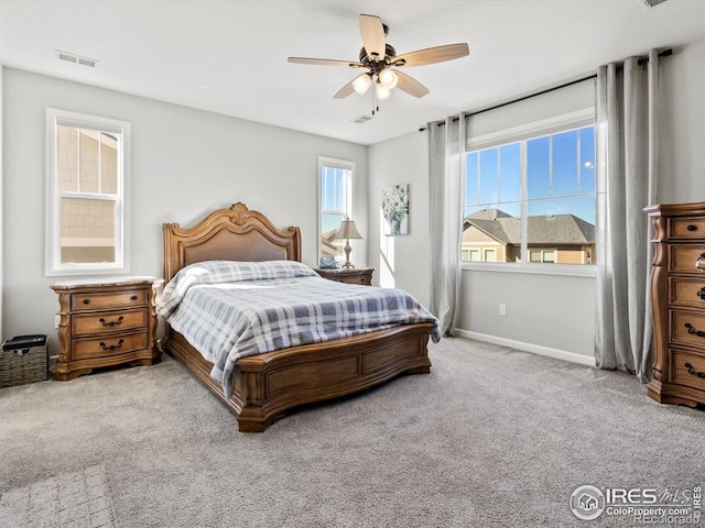 carpeted bedroom featuring a ceiling fan, baseboards, and visible vents