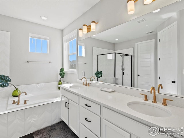 bathroom featuring double vanity, a shower stall, a sink, and a bath