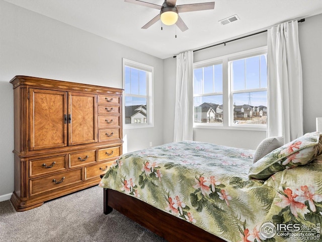 carpeted bedroom with ceiling fan and visible vents