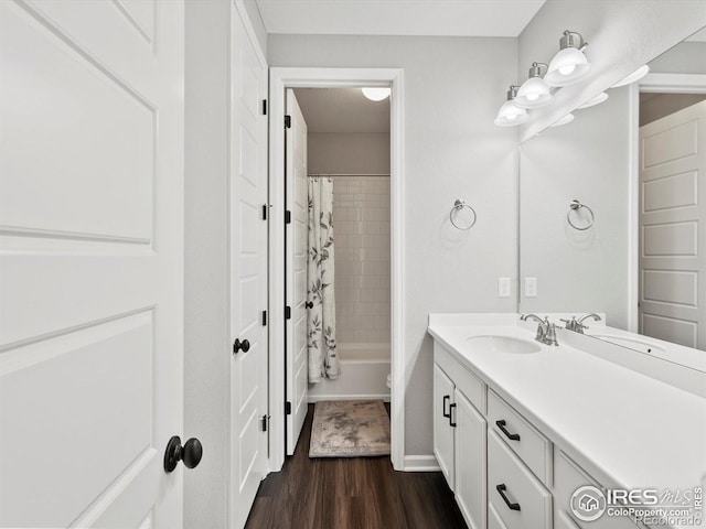 bathroom featuring vanity, baseboards, wood finished floors, and shower / bath combination with curtain
