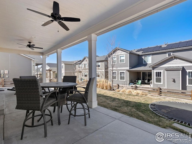 view of patio featuring outdoor dining area, ceiling fan, and a residential view