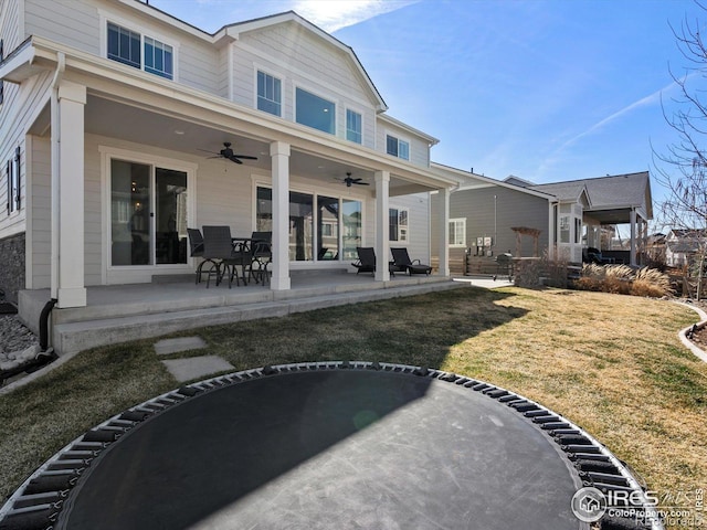 back of property with a patio, a ceiling fan, and a lawn
