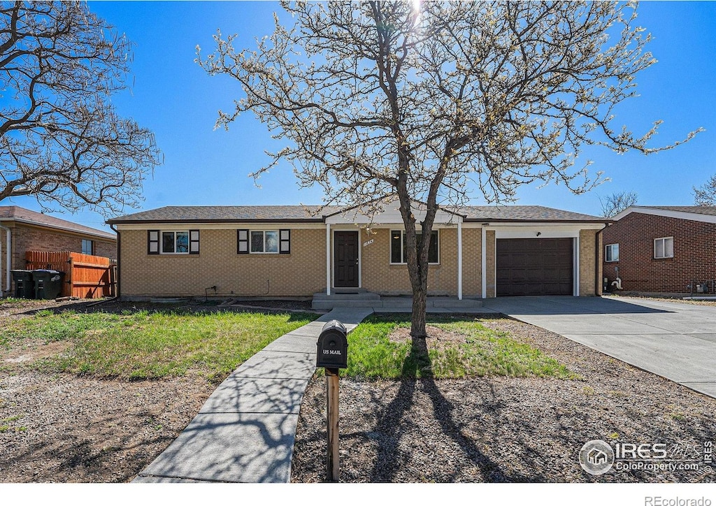 11674 Claude Ct, Northglenn, CO 80233 - ranch-style house featuring concrete driveway, brick siding, fence, and a garage
