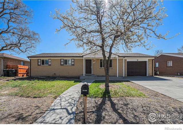 ranch-style house featuring concrete driveway, brick siding, fence, and a garage