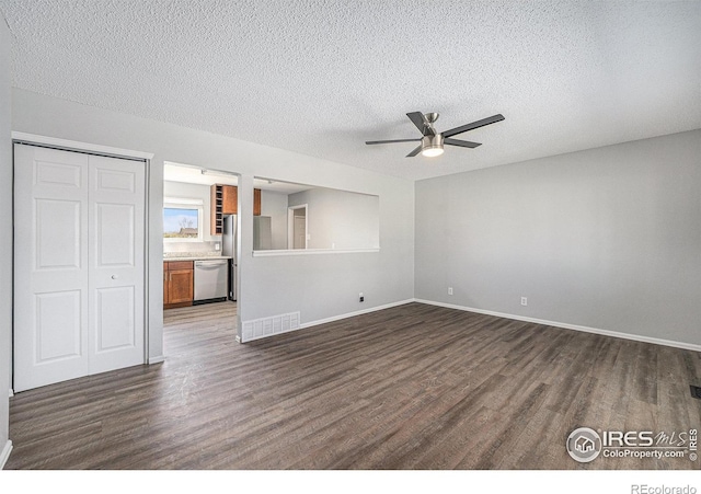 unfurnished living room with visible vents, dark wood-style flooring, baseboards, a textured ceiling, and a ceiling fan