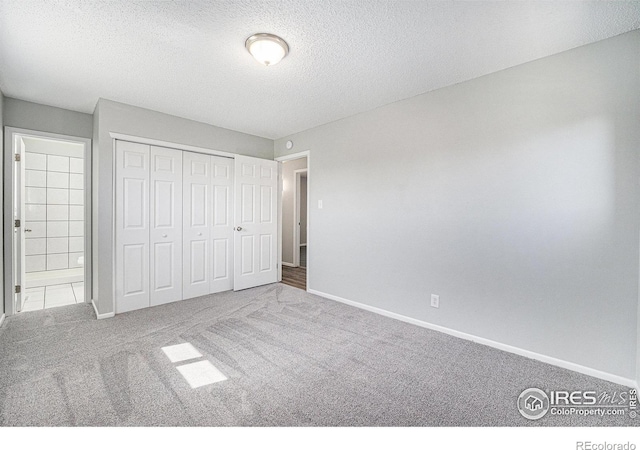 unfurnished bedroom with a closet, baseboards, carpet flooring, and a textured ceiling