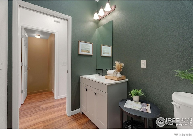 2832 William Neal Pkwy Unit C, Fort Collins, CO 80525 - half bathroom with baseboards, vanity, toilet, and wood finished floors