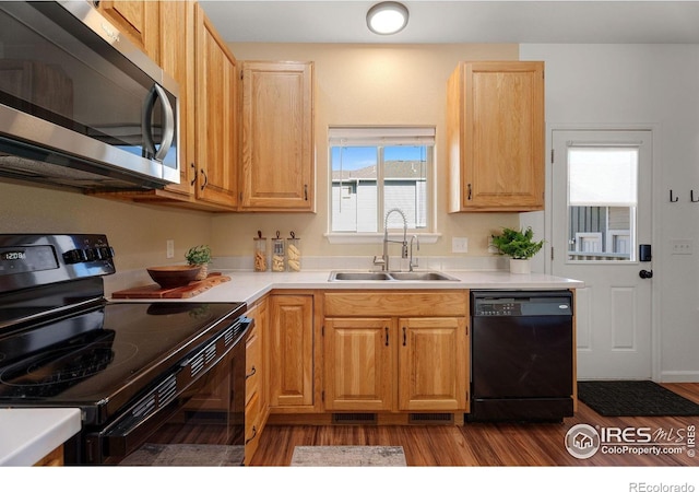 2832 William Neal Pkwy Unit C, Fort Collins, CO 80525 - kitchen featuring a sink, light countertops, black appliances, and dark wood finished floors