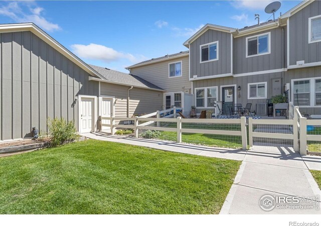 2832 William Neal Pkwy Unit C, Fort Collins, CO 80525 - rear view of house featuring a lawn, board and batten siding, and a fenced front yard