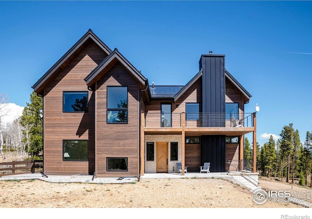 11 Juneau Cir, Nederland, CO 80466 - rear view of property featuring fence, a chimney, a balcony, a standing seam roof, and metal roof