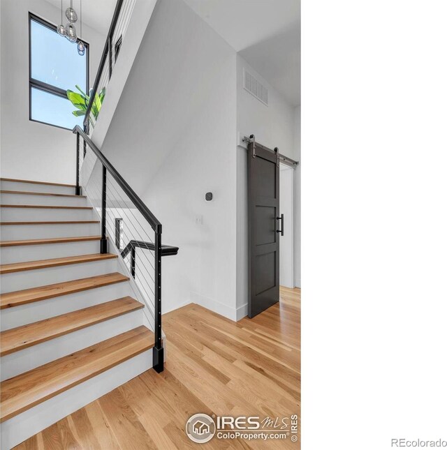 11 Juneau Cir, Nederland, CO 80466 - staircase with visible vents, a barn door, baseboards, and wood finished floors