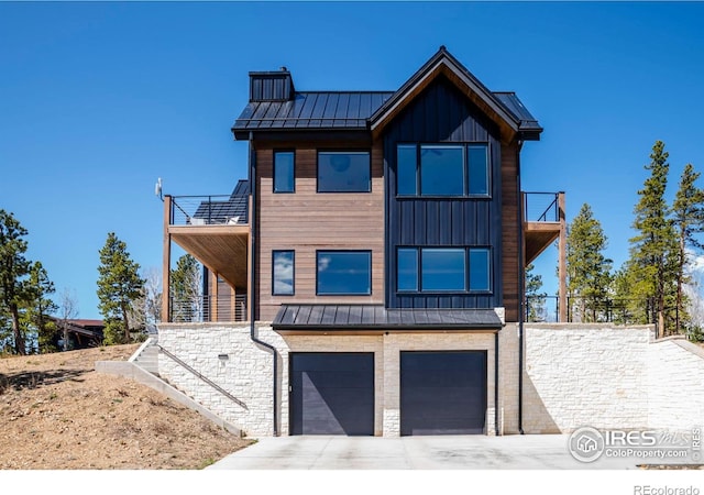 11 Juneau Cir, Nederland, CO 80466 - contemporary house featuring a standing seam roof, metal roof, a balcony, concrete driveway, and an attached garage