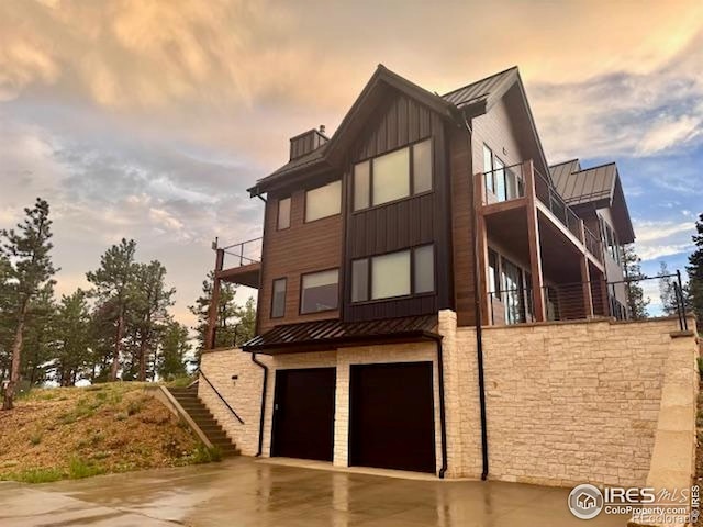 11 Juneau Cir, Nederland, CO 80466 - contemporary home featuring a standing seam roof, stairs, an attached garage, driveway, and a balcony