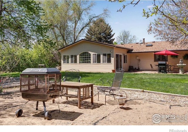 back of property with a lawn and a patio area