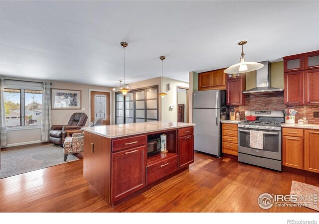 kitchen featuring wall chimney exhaust hood, stainless steel appliances, dark wood-style floors, open floor plan, and decorative backsplash