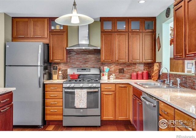 kitchen featuring appliances with stainless steel finishes, a sink, wall chimney range hood, dark wood finished floors, and recessed lighting