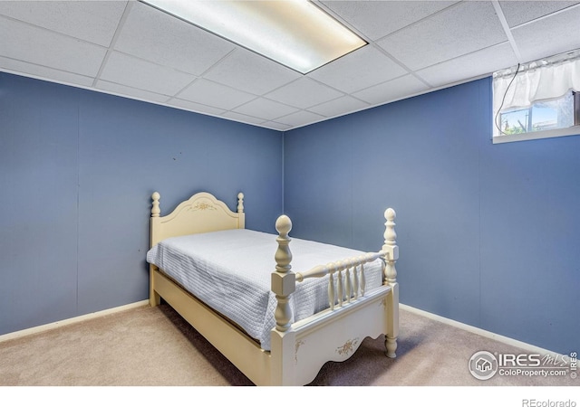 bedroom with carpet floors, a drop ceiling, and baseboards