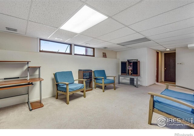 sitting room featuring carpet floors and a paneled ceiling
