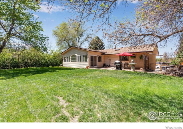 rear view of house with a patio and a yard