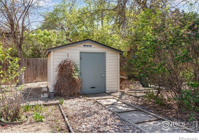 view of shed featuring fence