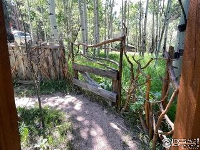 view of gate with a wooded view