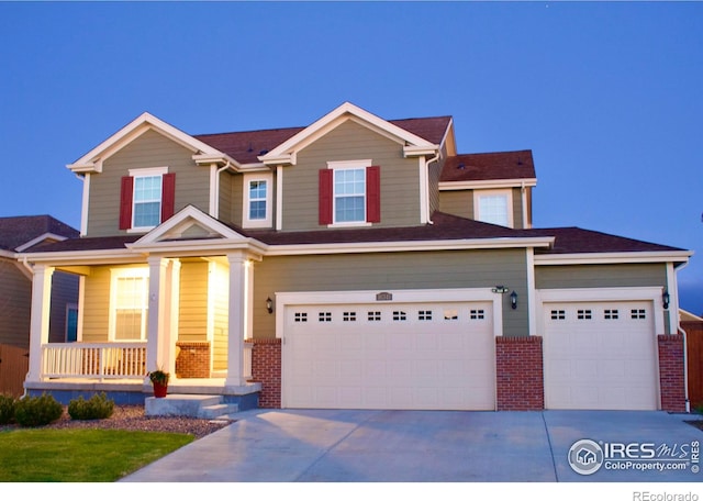 craftsman-style home with covered porch, concrete driveway, and brick siding