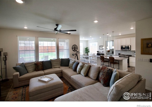 living area featuring a ceiling fan, baseboards, recessed lighting, and wood finished floors