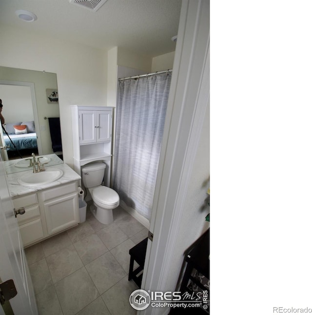 ensuite bathroom featuring vanity, toilet, ensuite bathroom, a shower with shower curtain, and tile patterned floors