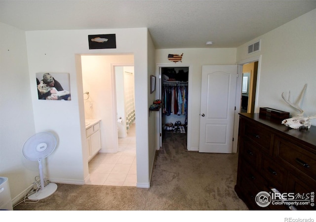 bedroom featuring baseboards, visible vents, a closet, and light colored carpet