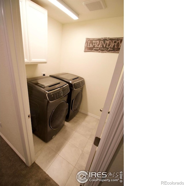 clothes washing area with cabinet space, baseboards, light tile patterned floors, visible vents, and washer and clothes dryer