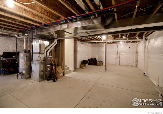 unfinished basement with stairs, heating unit, and gas water heater