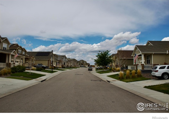 view of street featuring street lights, sidewalks, and a residential view