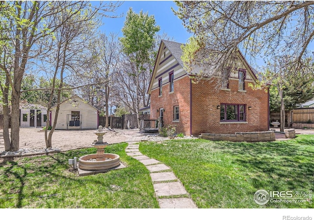 exterior space with fence, a yard, a patio area, and brick siding