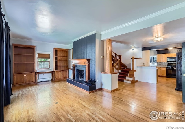 living room featuring baseboard heating, a fireplace, stairway, light wood finished floors, and ornamental molding