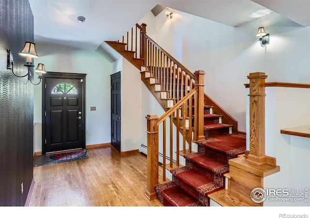 foyer entrance with stairway, baseboards, and wood finished floors