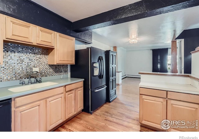 kitchen with light brown cabinets, tasteful backsplash, a sink, light wood-style flooring, and black appliances