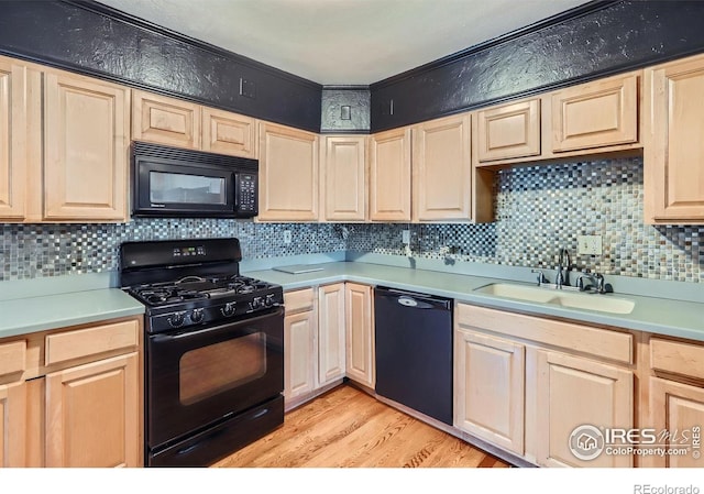 kitchen with light brown cabinets and black appliances