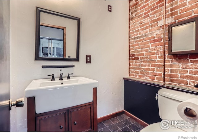 bathroom with toilet, baseboards, tile patterned flooring, and vanity