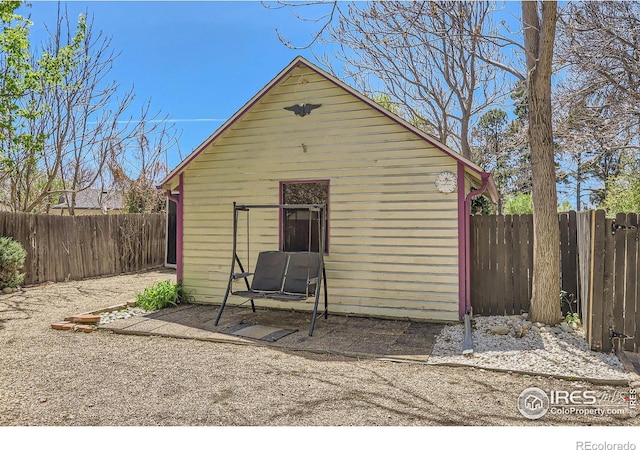 view of outdoor structure with a fenced backyard and an outbuilding