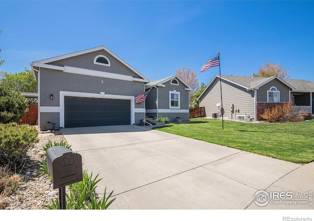 ranch-style house with fence, stucco siding, driveway, and a front yard