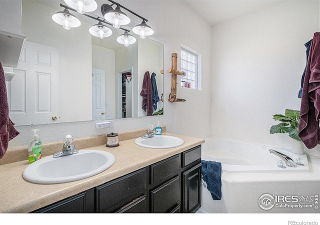 bathroom featuring double vanity, a sink, and a bath